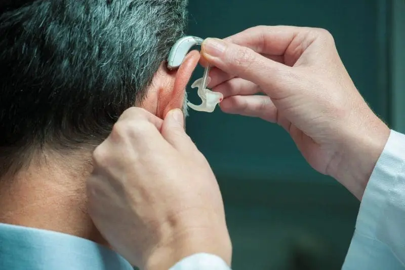 A person putting on an ear piece